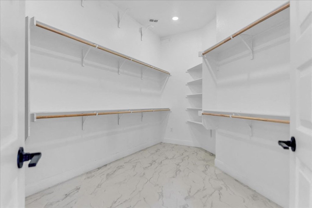 a white closet with shelves and a marble floor