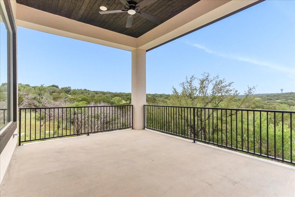 a covered porch with a view of the grass and trees