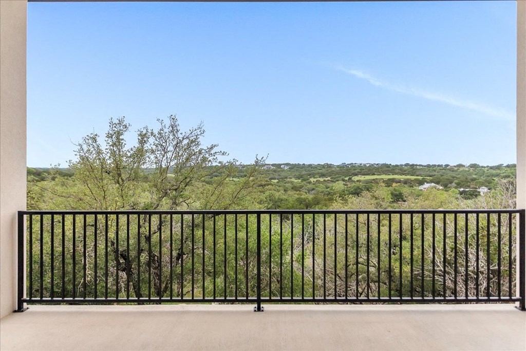 a balcony with a view of a field and trees