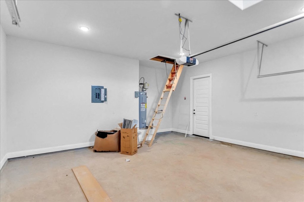 a white room with a ladder in the ceiling and boxes on the floor