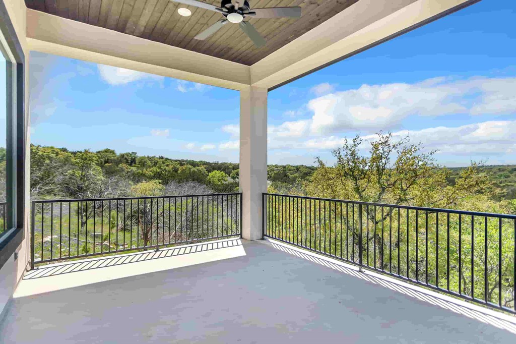 a covered porch with a view of the trees and the river