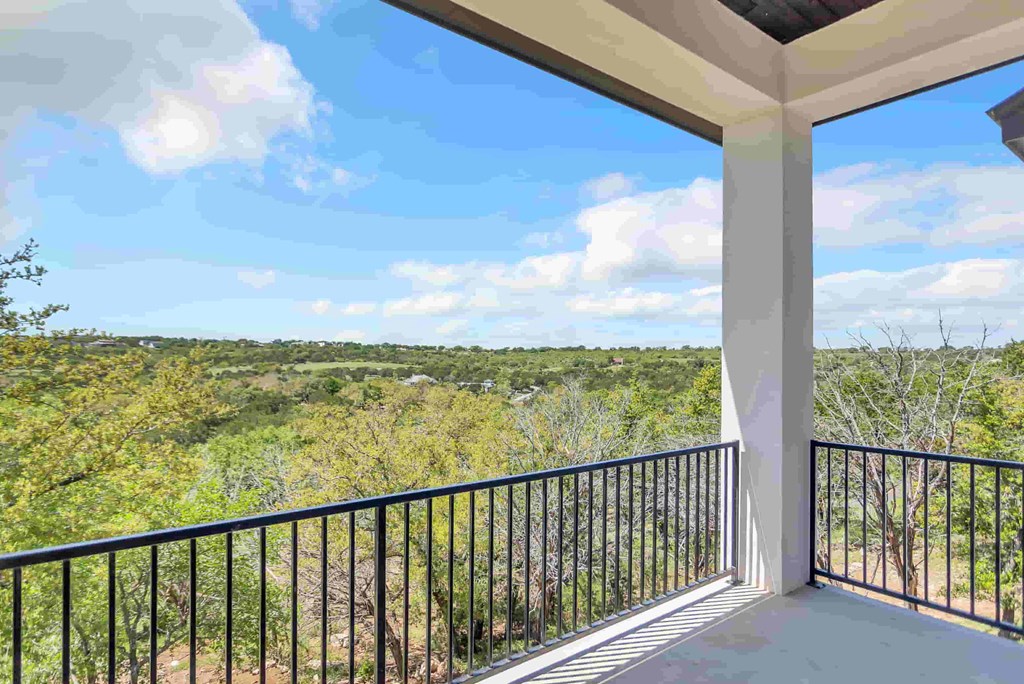 a view from the balcony of a house overlooking the woods