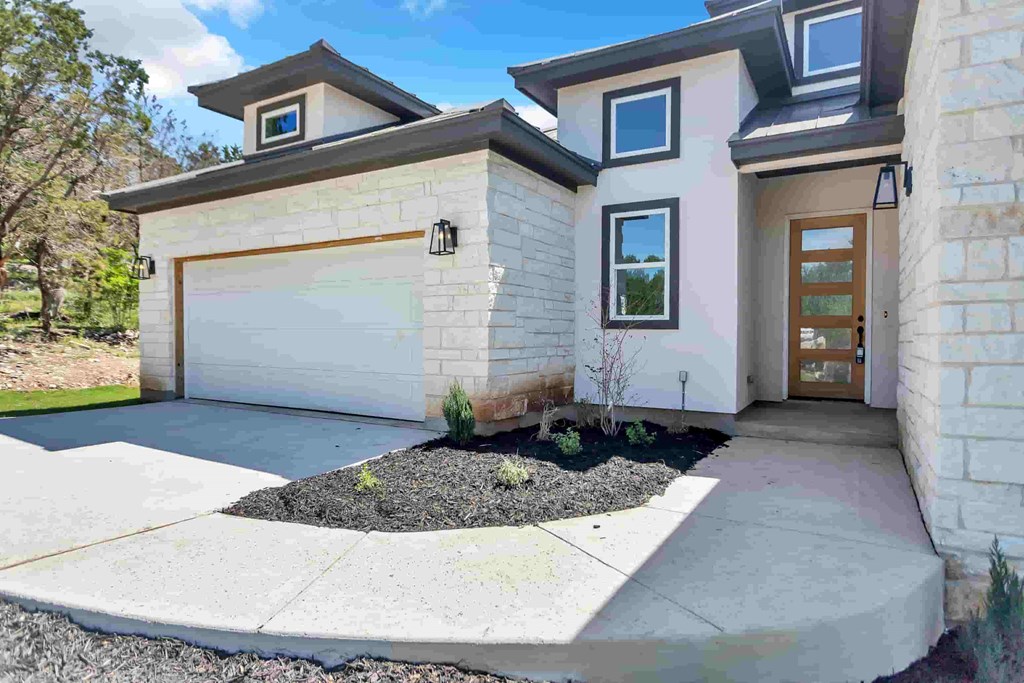 a white house with a driveway and a garage door