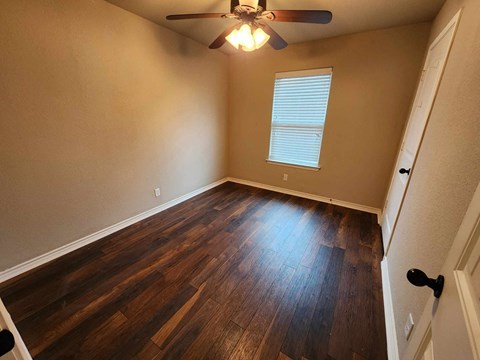 a living room with hard wood floors and a ceiling fan