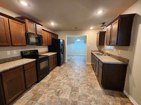 a kitchen with wood cabinets and black appliances