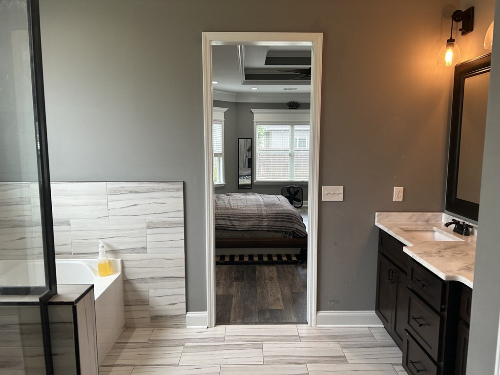 a bedroom and a bathroom with a tub and a bed