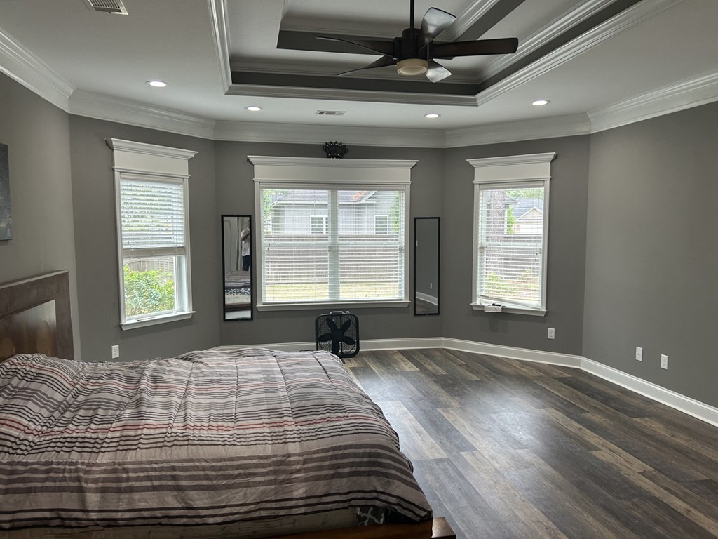a master bedroom with a large bed and a ceiling fan