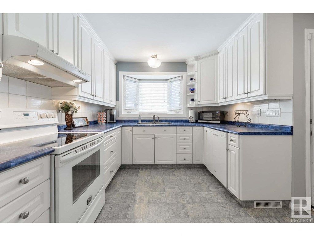 a white kitchen with white cabinets and blue counter tops