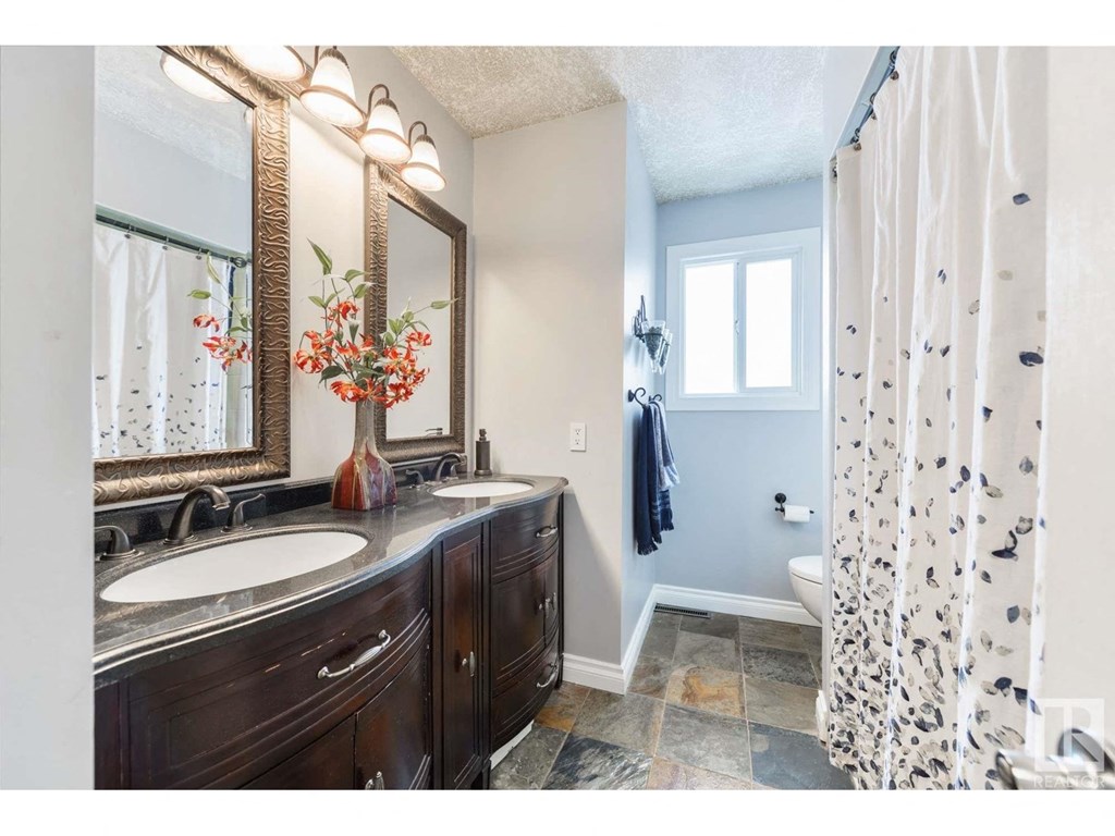 a bathroom with two sinks and a shower and a toilet