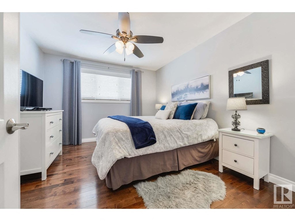a bedroom with a bed and a ceiling fan