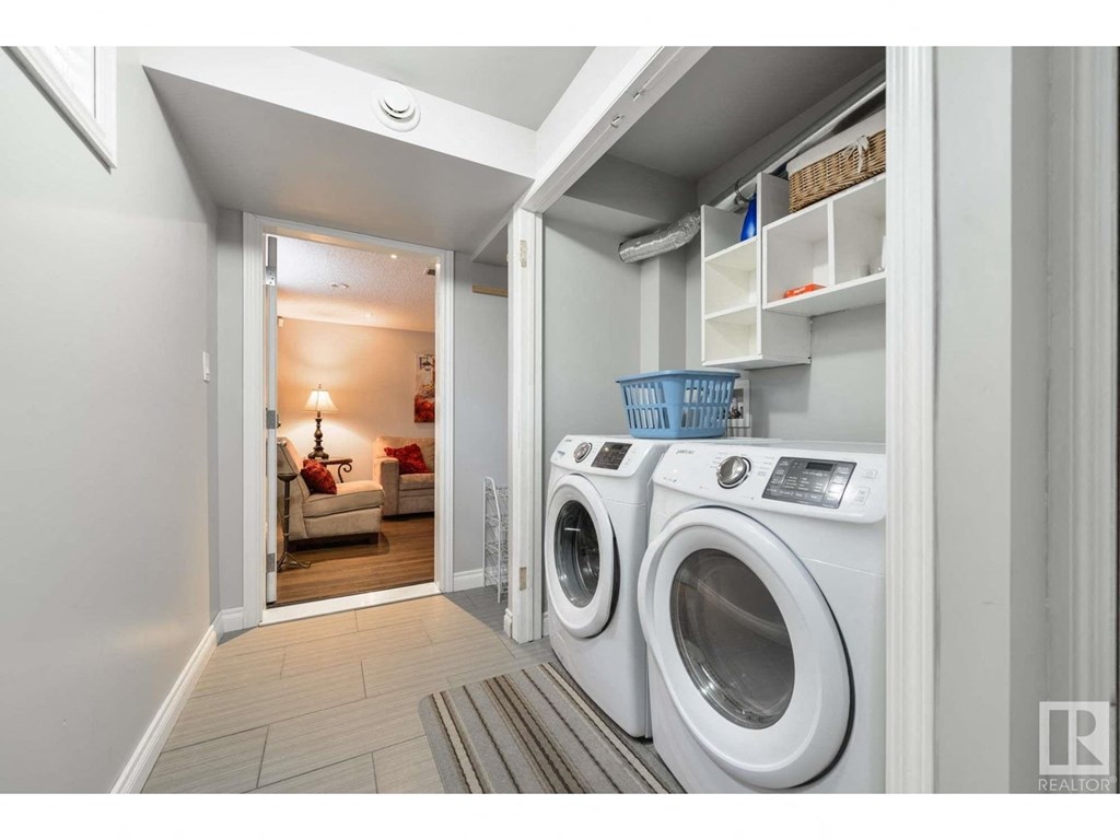 a white washer and dryer in a room with a door to a bathroom
