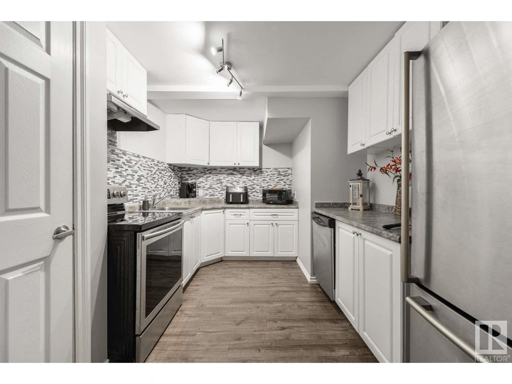 a kitchen with white cabinets and stainless steel appliances