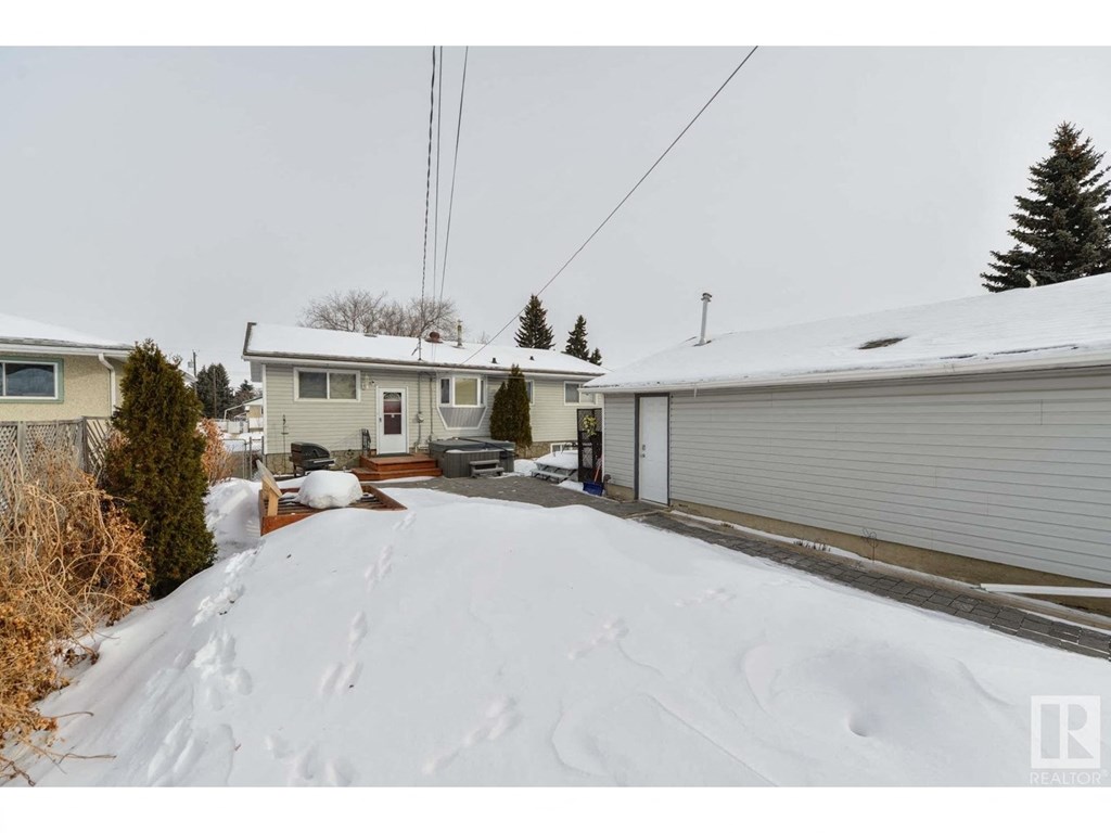 a snow covered driveway in front of a white house