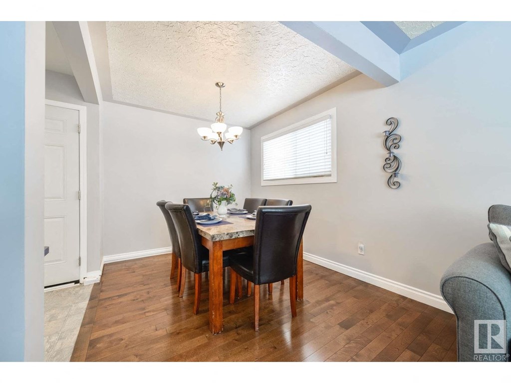 a dining room with a wooden table and chairs