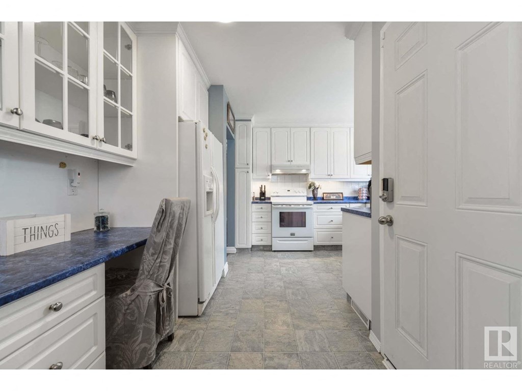 a white kitchen with white cabinets and white appliances