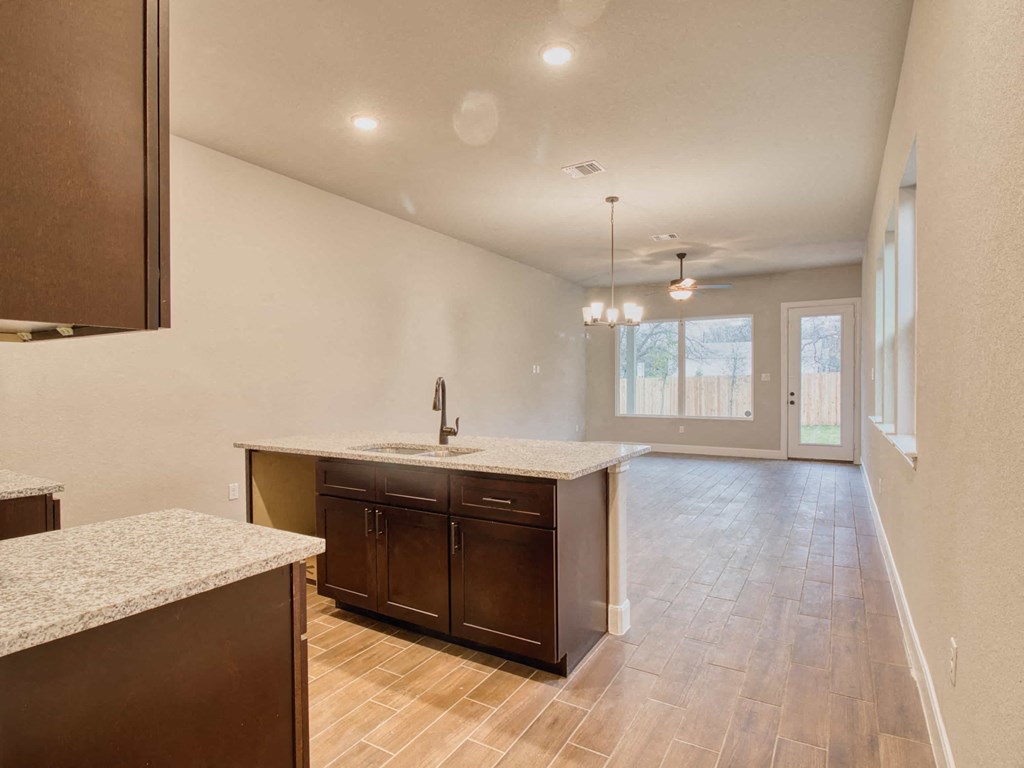 an empty kitchen with an empty living room next to it
