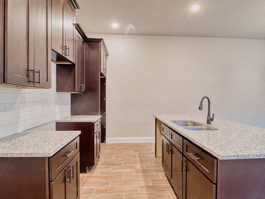 a kitchen with marble counter tops and wooden cabinets