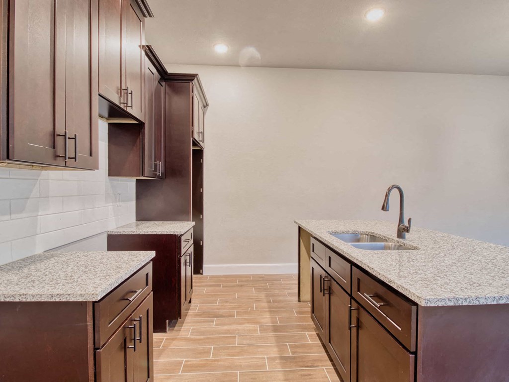 a kitchen with marble counter tops and wooden cabinets