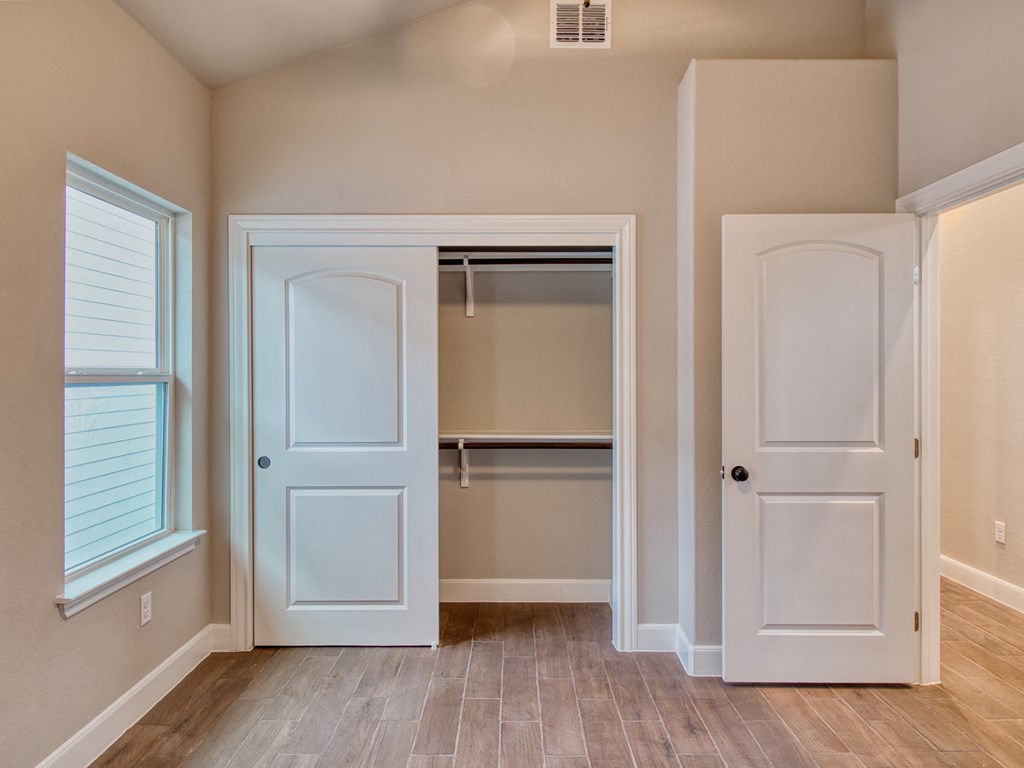 an empty room with a closet and a door to a closet