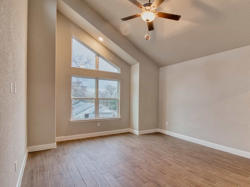 the spacious living room with hardwood floors and a large window