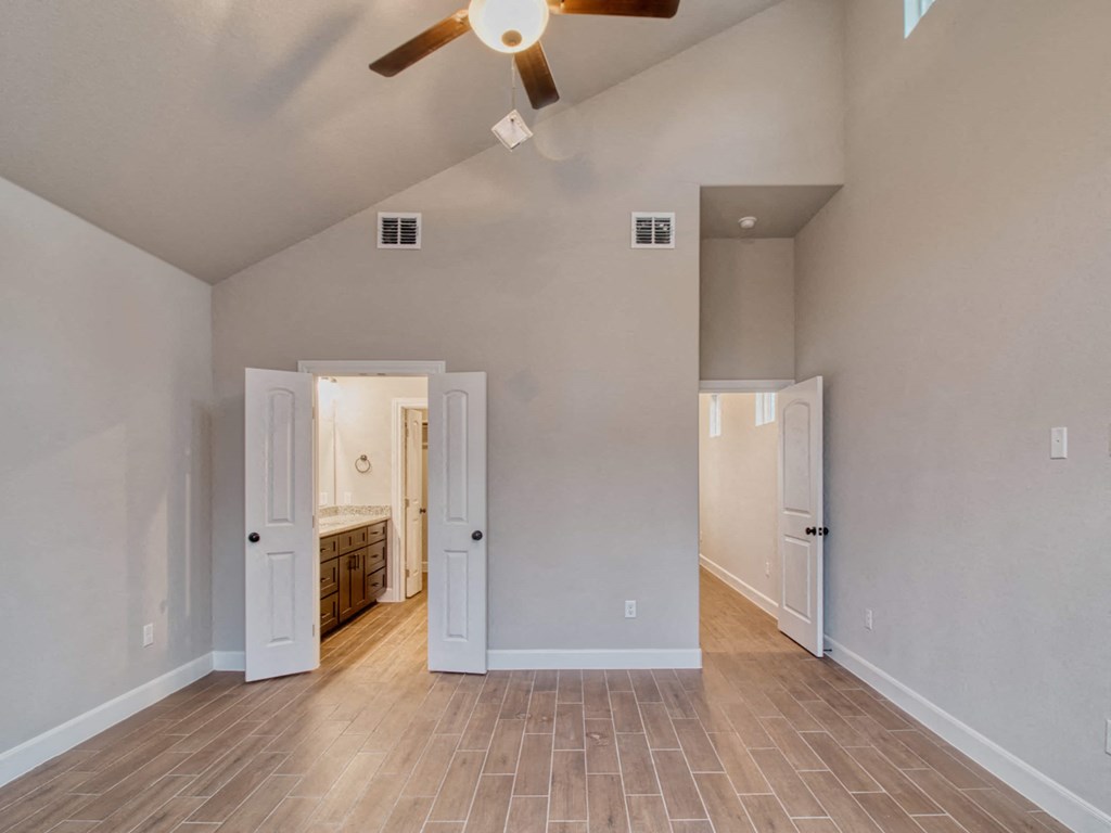 a living room with a ceiling fan and a door to a bathroom