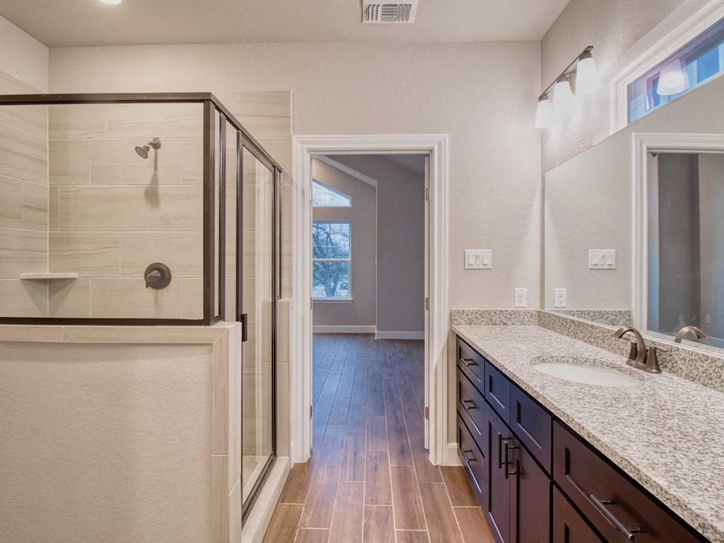 a bathroom with a shower and a sink and a mirror