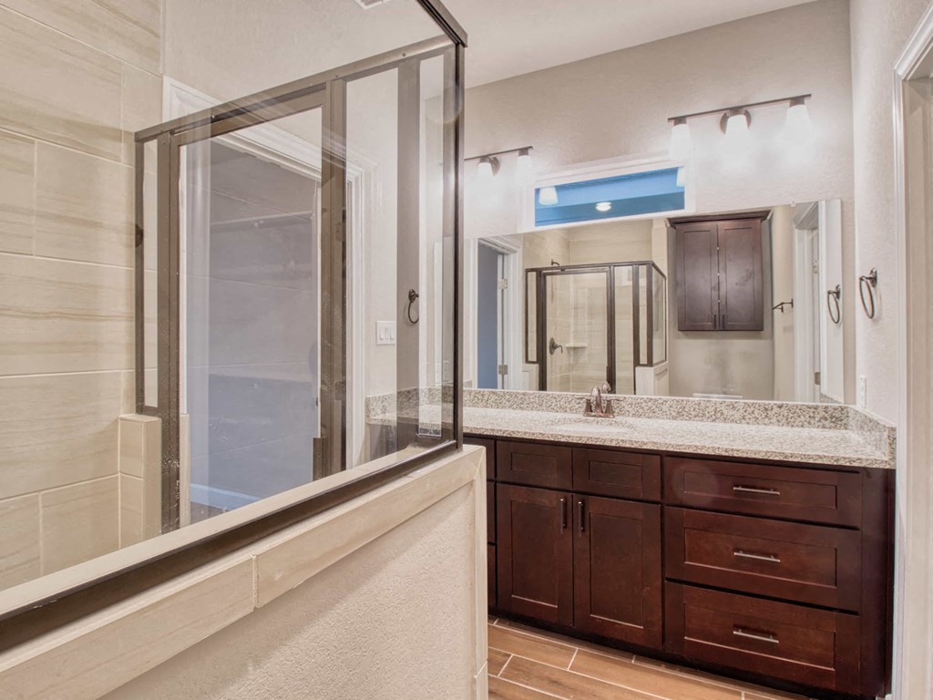 a bathroom with a shower and a sink and a mirror