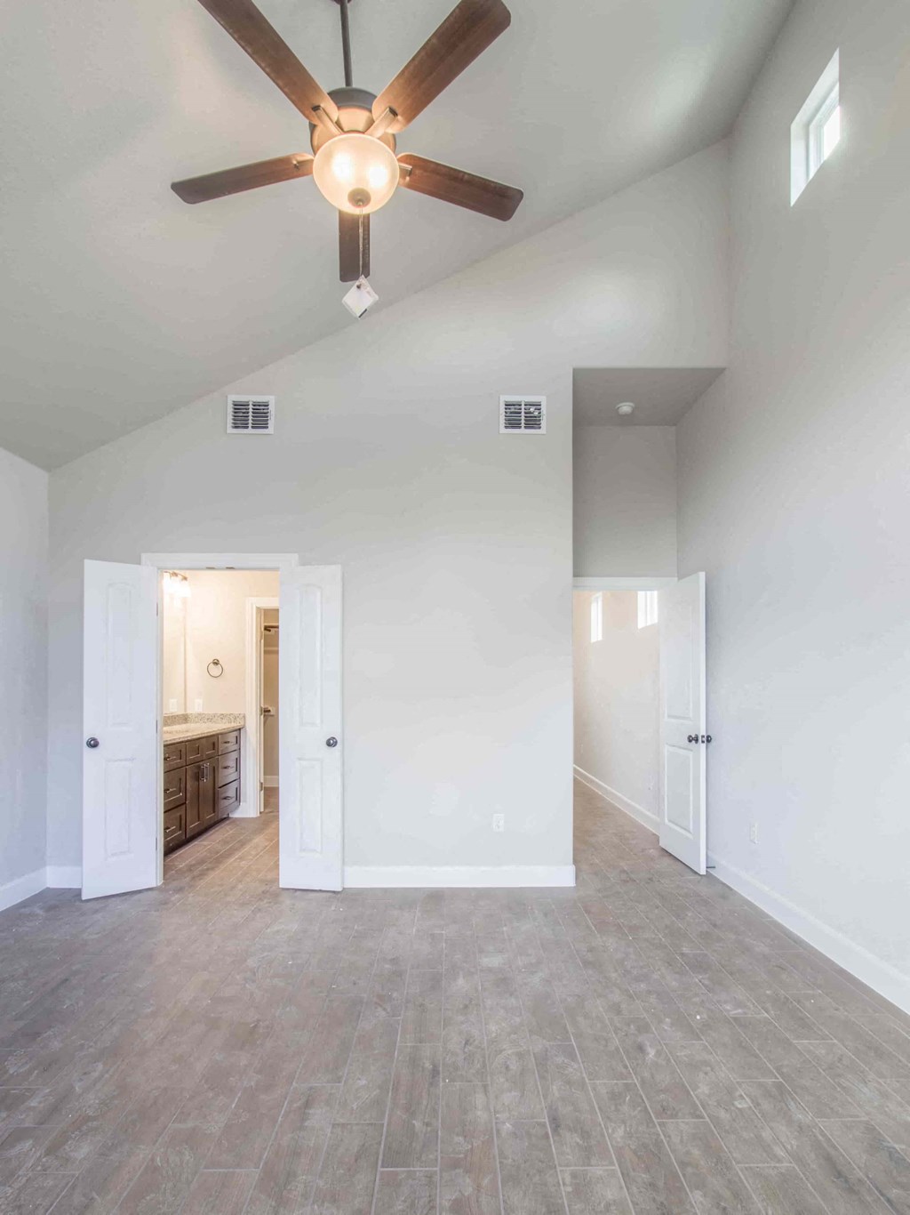 an empty living room with a ceiling fan