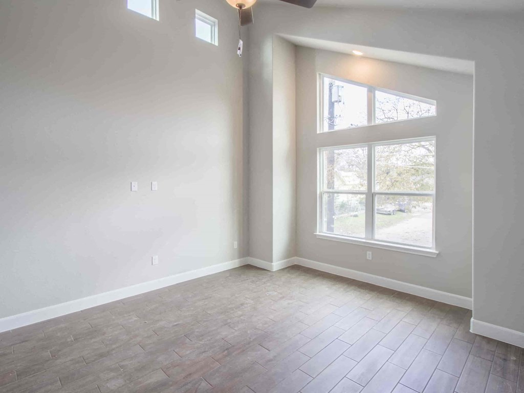an empty living room with white walls and a window