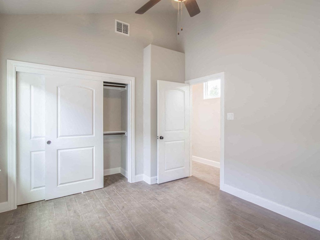 an empty room with white doors and a closet