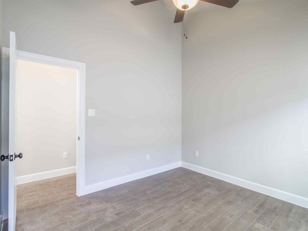 a room with white walls and a ceiling fan