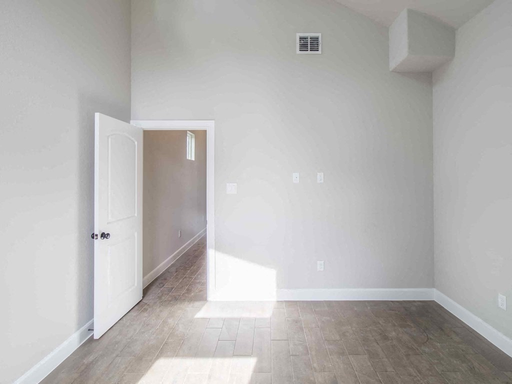 an empty living room with white walls and wood floors