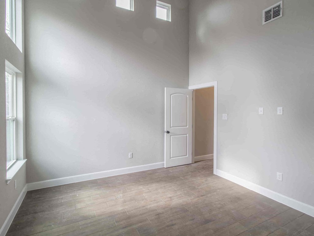 an empty room with white walls and a door and wood floors