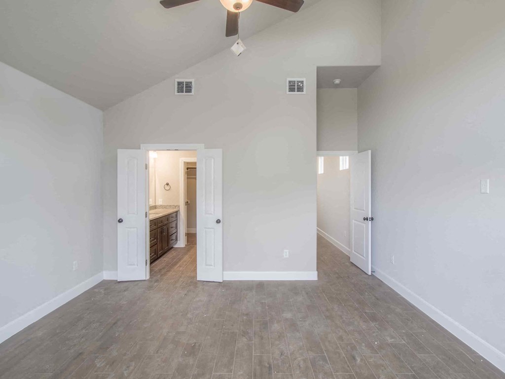 an empty living room with white walls and a ceiling fan