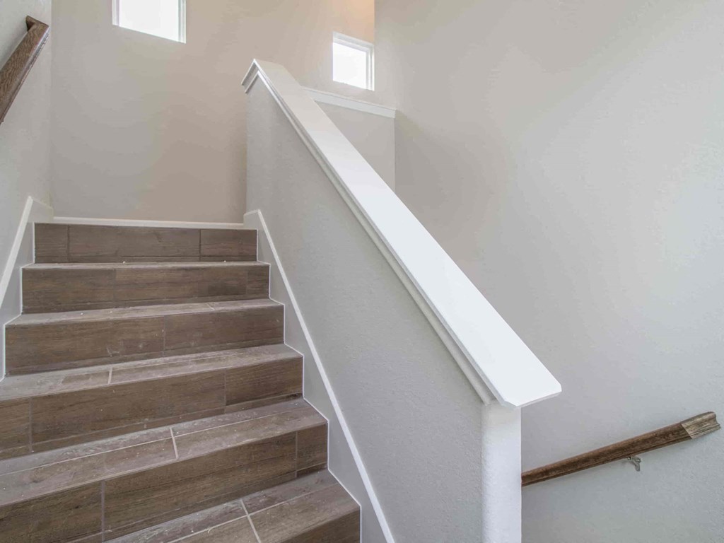 stairs in a home with white walls and wood steps