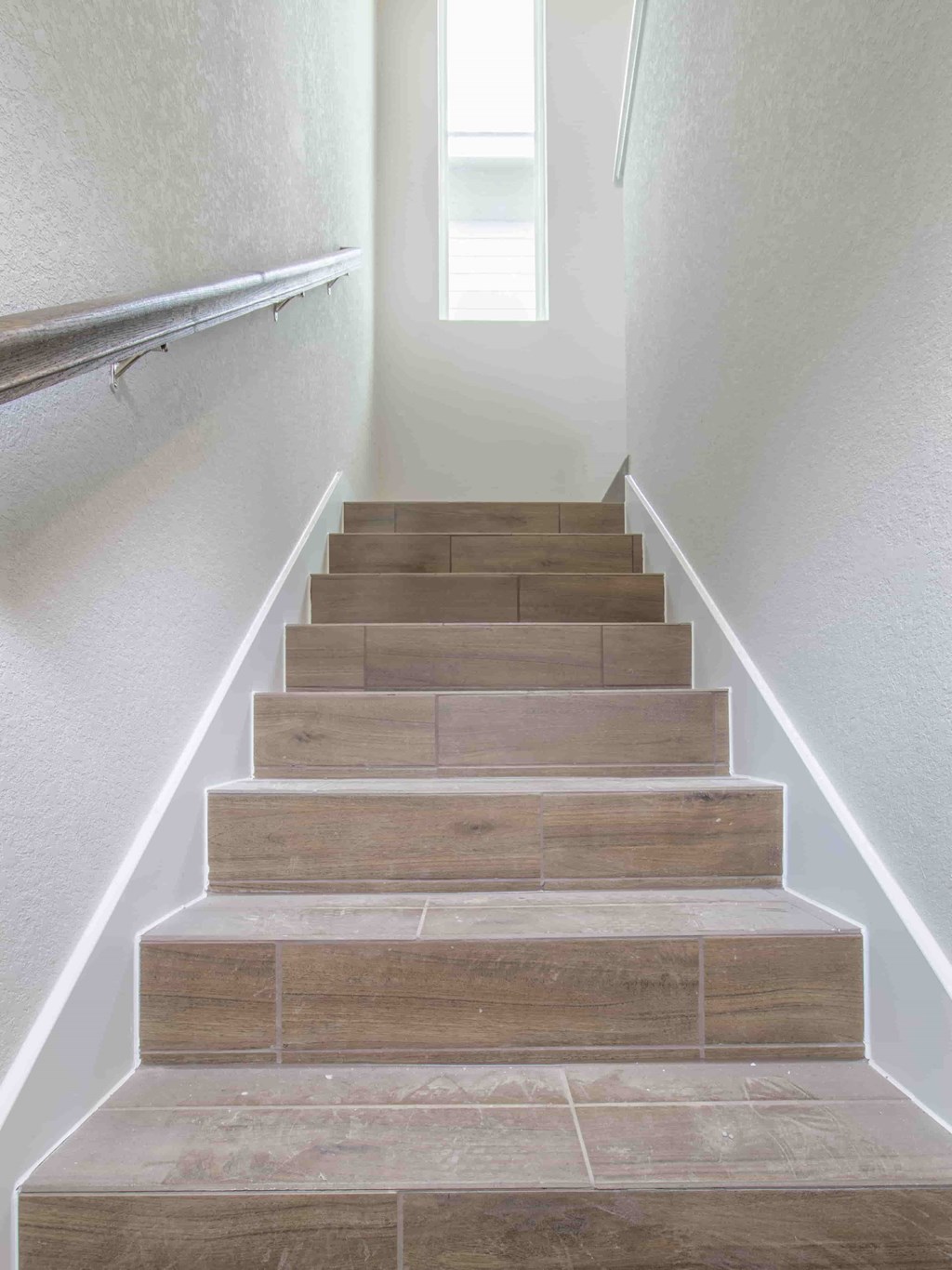 stairs in a home leading up to a landing with a window