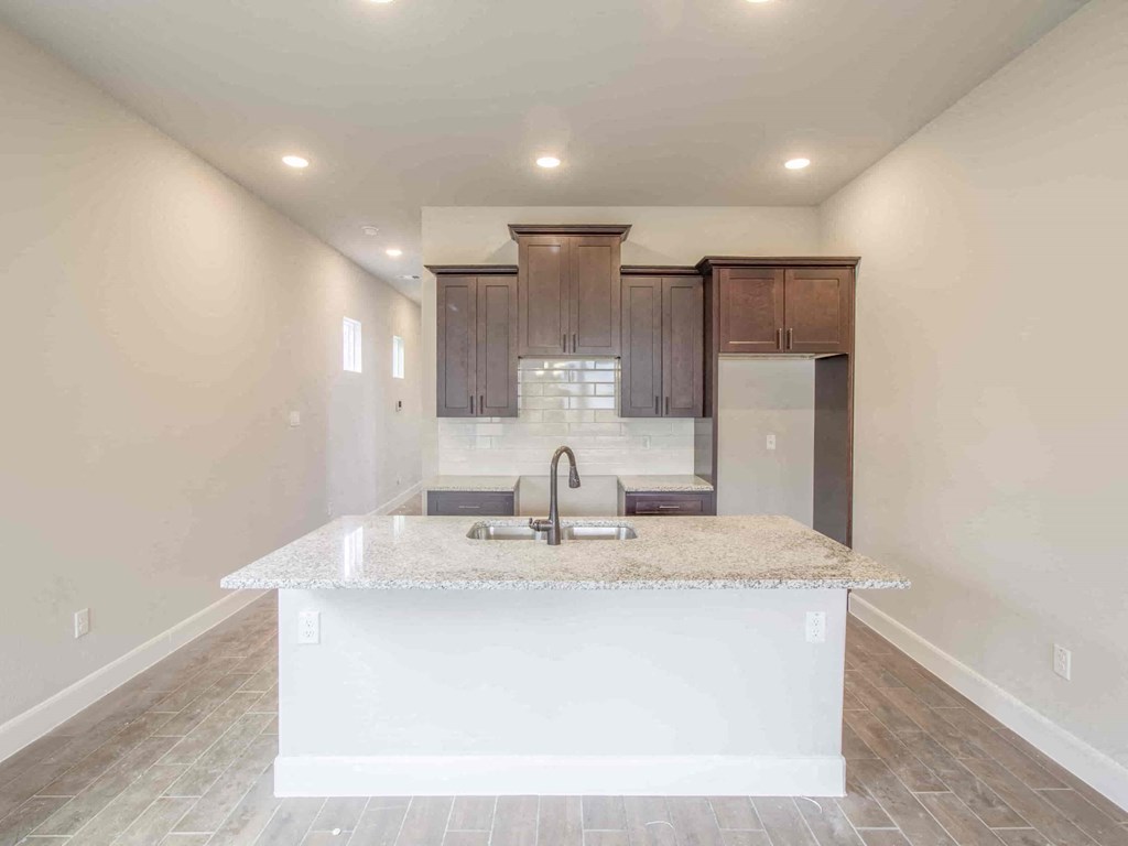 an empty kitchen with a sink and a counter top