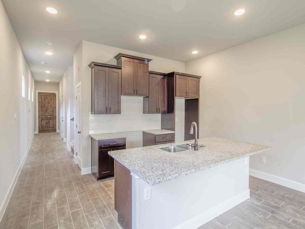 an empty kitchen with a counter top and a sink