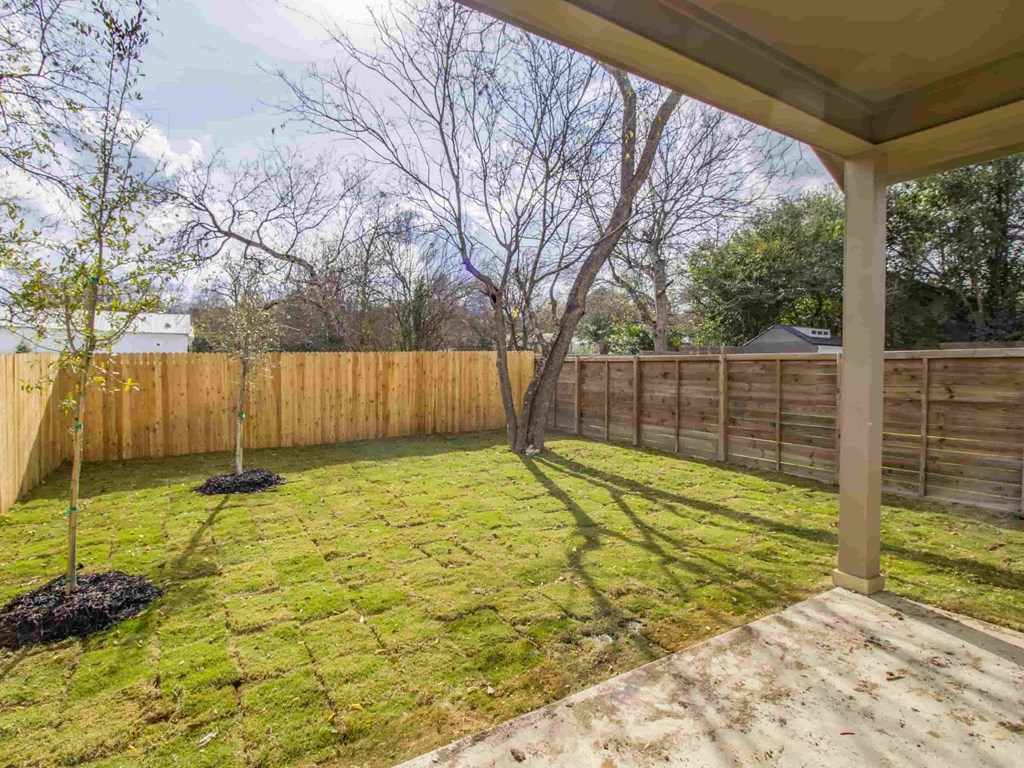 a backyard with a wooden privacy fence and a porch