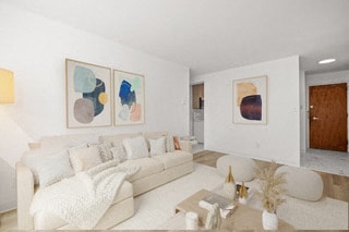 a living room with white furniture and paintings on the wall
