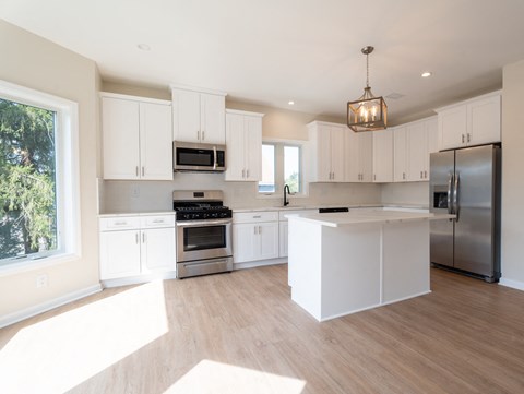 A modern kitchen with white cabinets and stainless steel appliances.