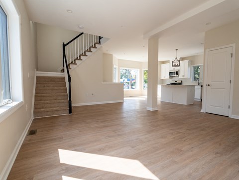 A spacious living room with a staircase leading to the upper floor.
