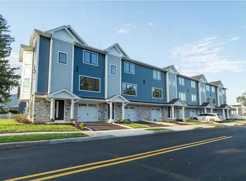 A row of houses with garages and driveways.