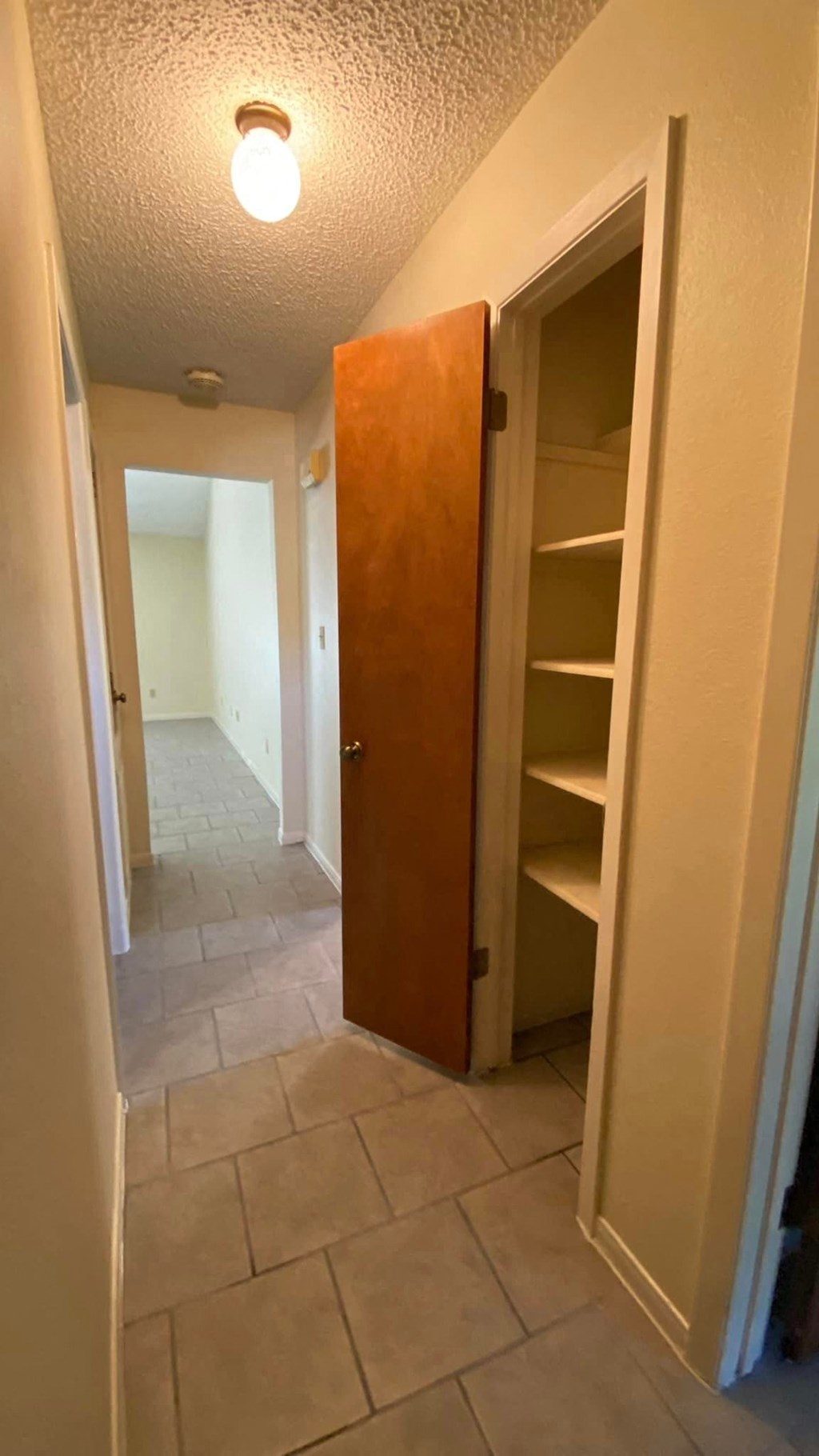 a bathroom with a closet and a hallway with an open door