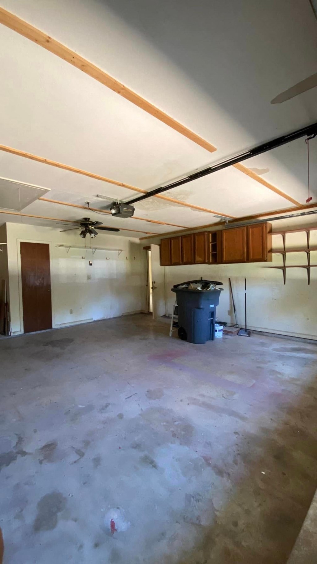 a large unfinished garage with a sink and a trash can in it