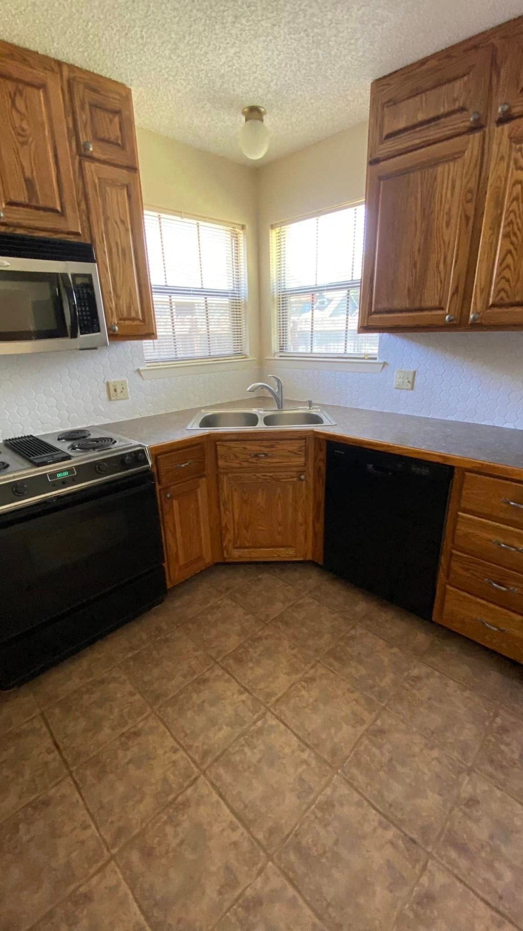 an empty kitchen with wooden cabinets and a sink