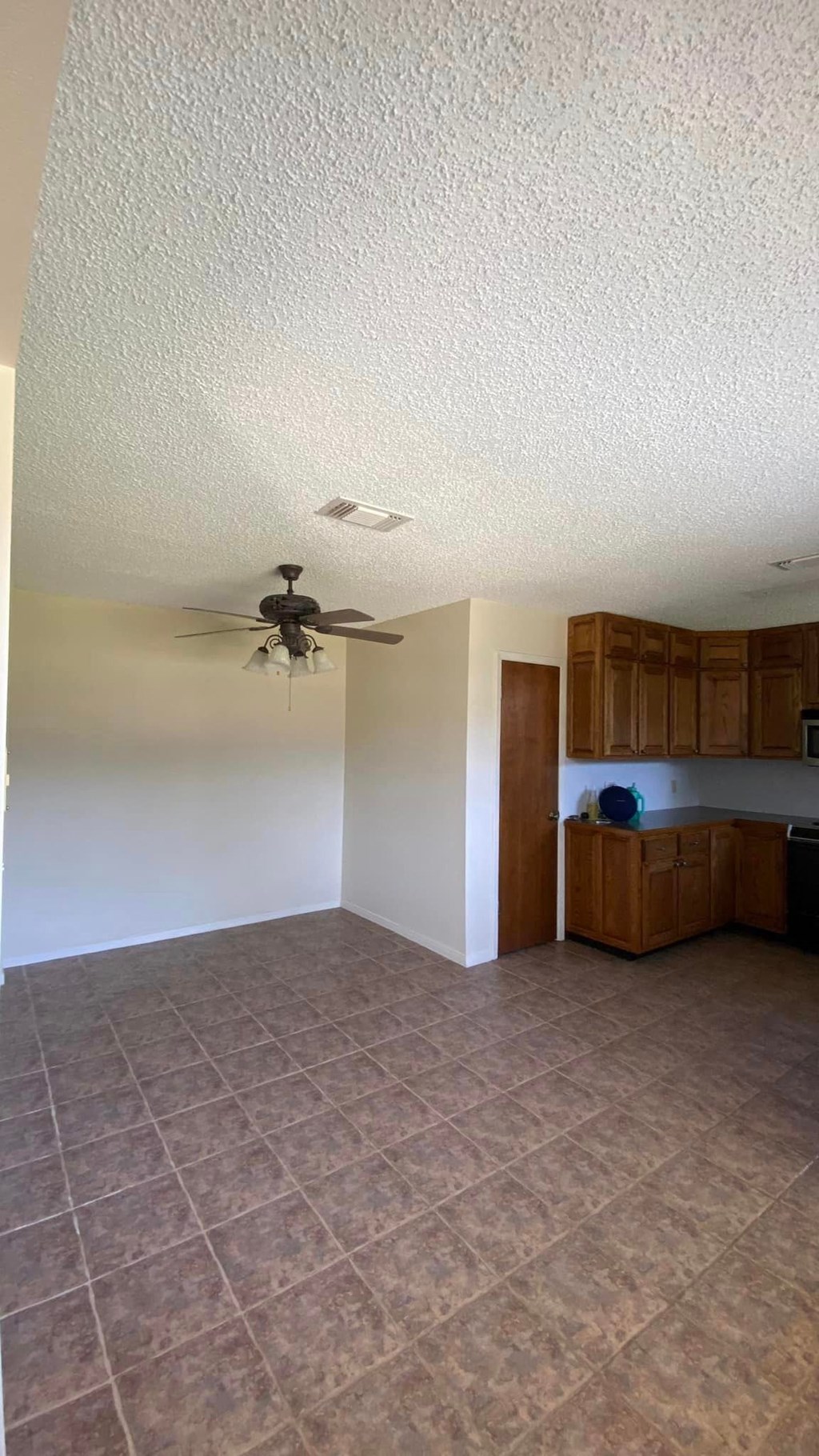 an empty living room with a ceiling fan