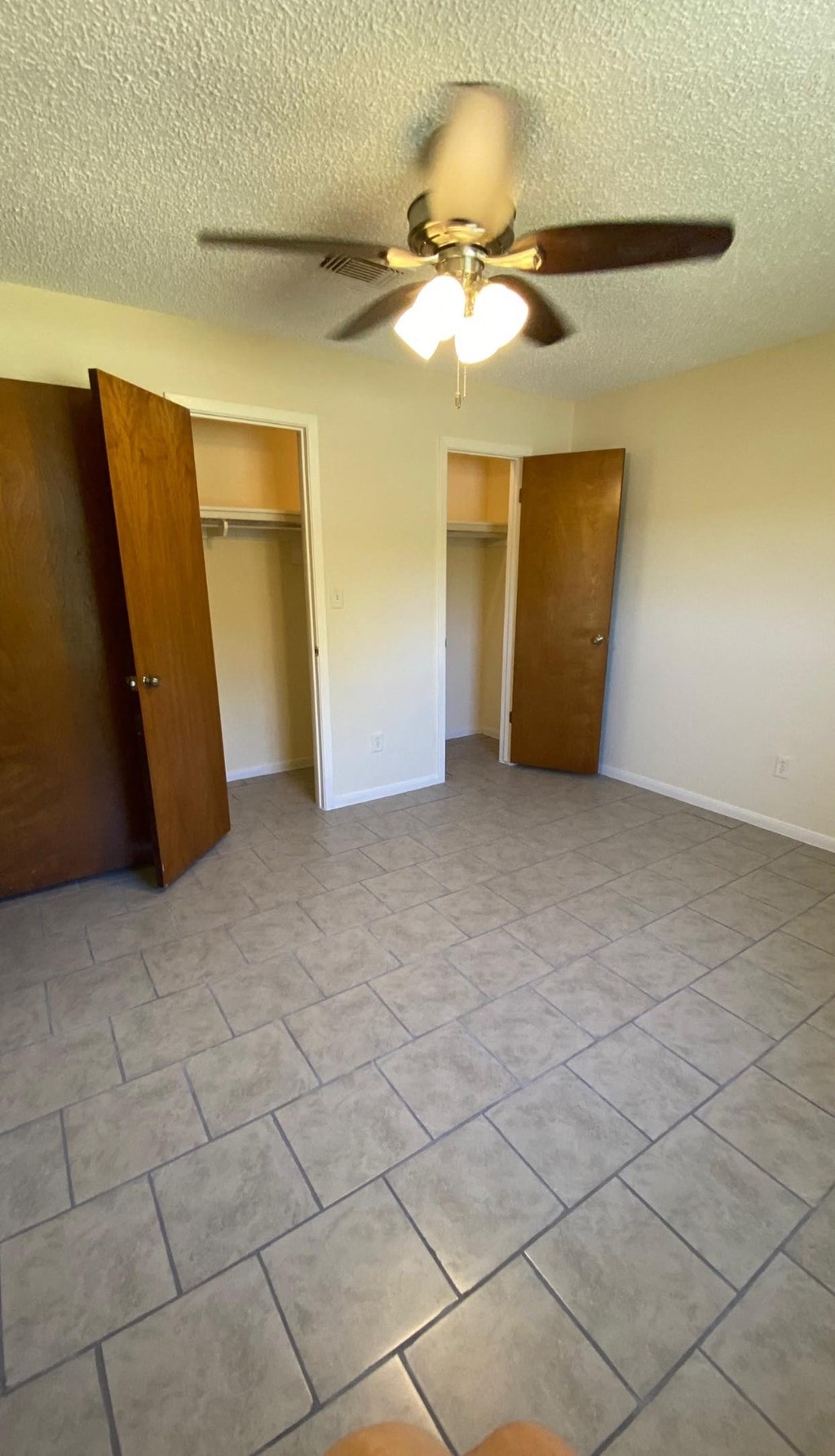 an empty living room with a ceiling fan