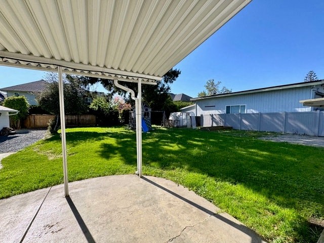 a backyard with a covered patio and a yard with green grass