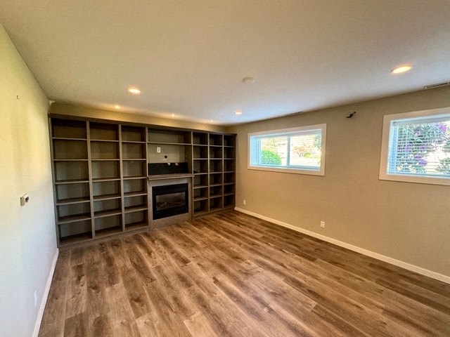 an empty living room with a fireplace and shelves